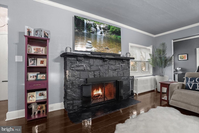 living room featuring a textured ceiling, radiator heating unit, dark wood-type flooring, a stone fireplace, and crown molding