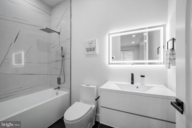 full bathroom featuring vanity, tiled shower / bath combo, and toilet