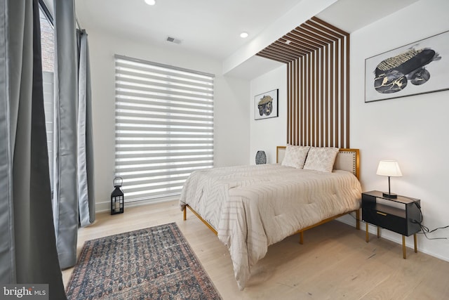 bedroom with light hardwood / wood-style floors and multiple windows