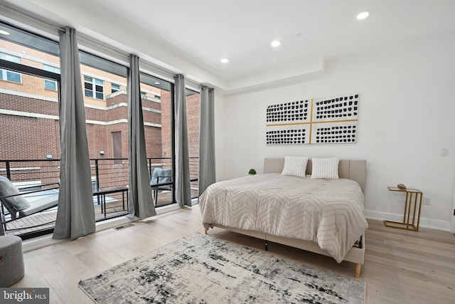 bedroom with access to exterior and light hardwood / wood-style flooring