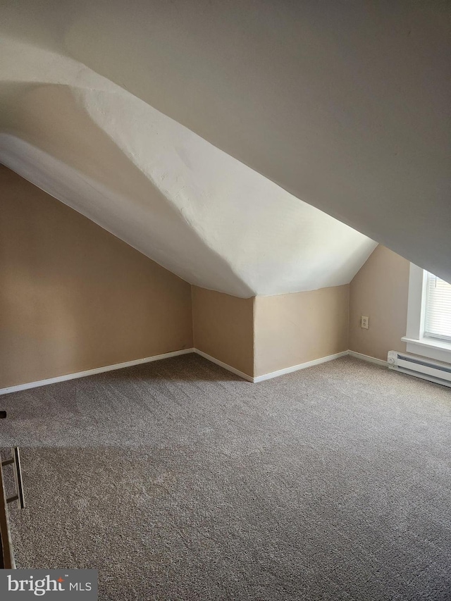 additional living space featuring carpet floors, a baseboard radiator, and vaulted ceiling