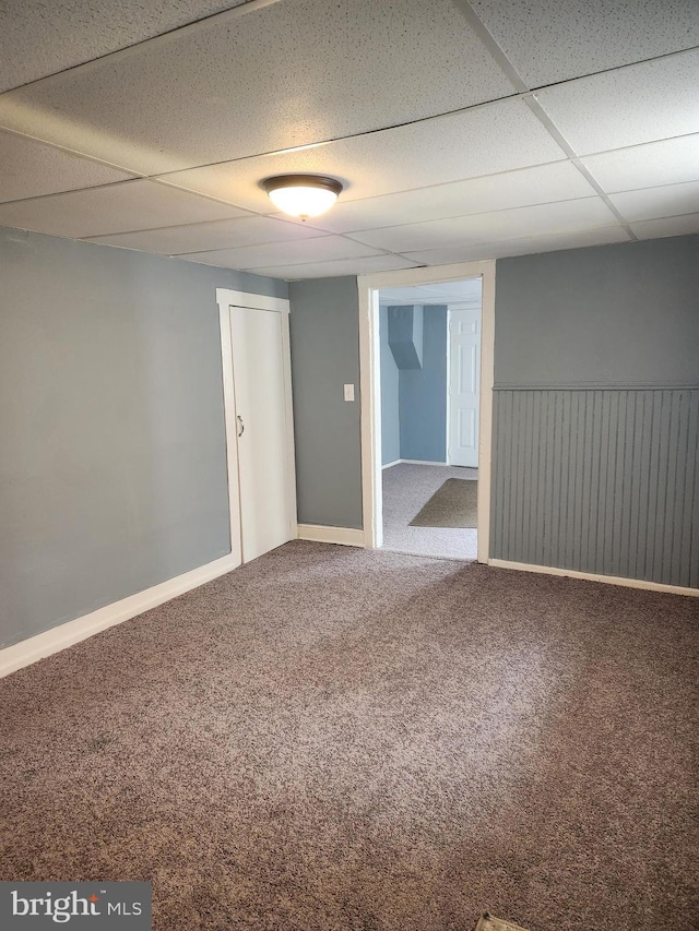 empty room with carpet flooring and a drop ceiling