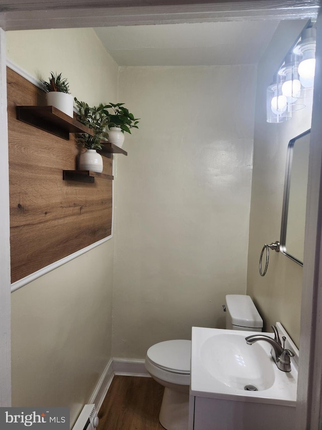 bathroom with baseboard heating, vanity, wood-type flooring, and toilet