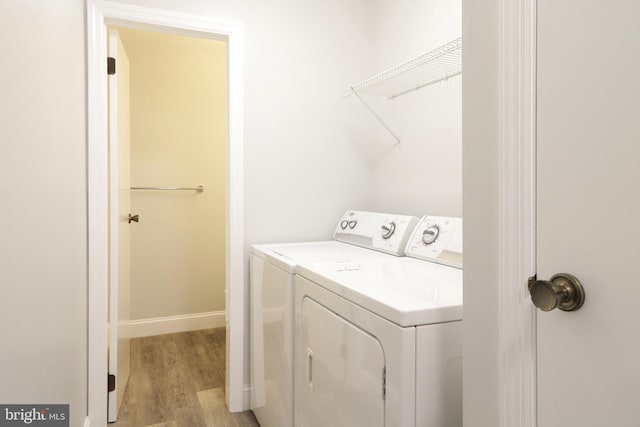 laundry area with washing machine and dryer and light hardwood / wood-style floors