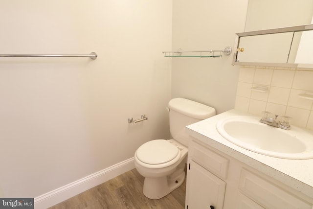 bathroom with vanity, backsplash, hardwood / wood-style flooring, and toilet