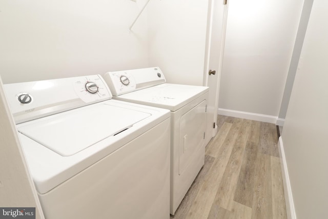 laundry area featuring washer and clothes dryer and light hardwood / wood-style floors