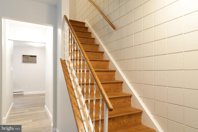 stairway featuring hardwood / wood-style flooring, baseboard heating, and a wall unit AC