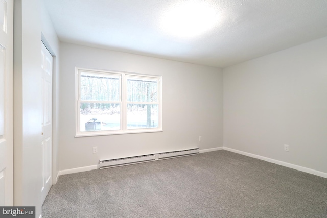 carpeted empty room featuring baseboard heating