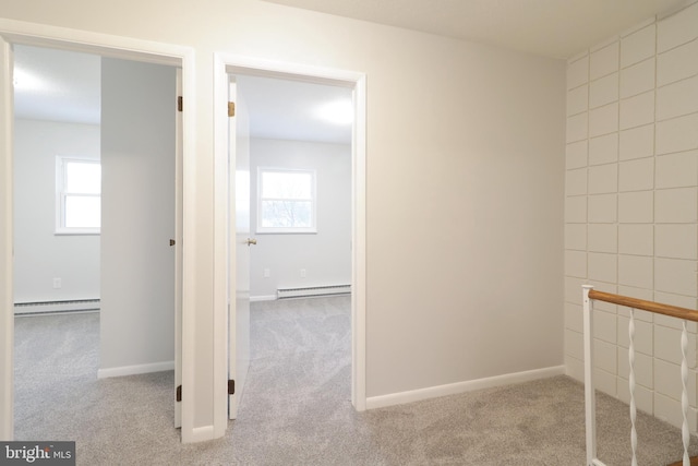 hall with light colored carpet and a baseboard radiator