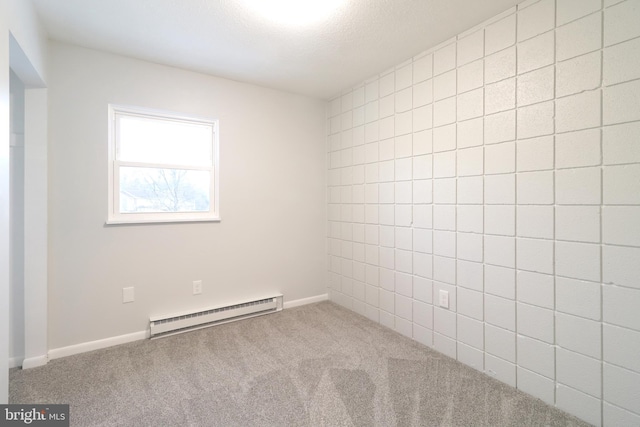 carpeted empty room featuring baseboard heating and a textured ceiling