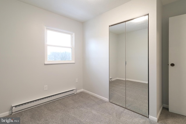 unfurnished bedroom featuring baseboard heating, light carpet, and a closet