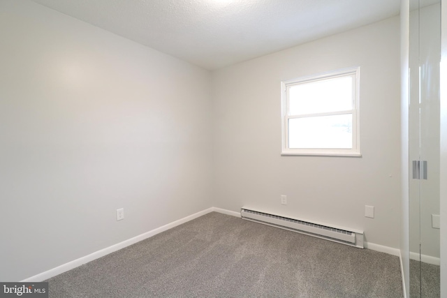 spare room featuring carpet and a baseboard radiator