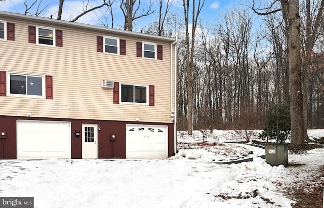 view of snow covered exterior with a garage