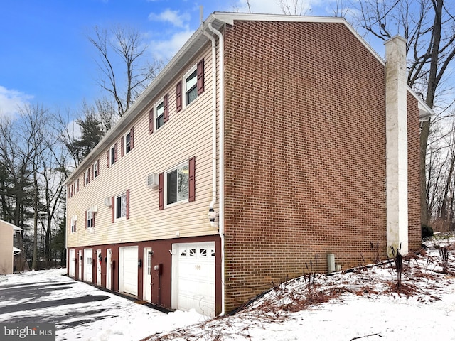 view of snow covered exterior featuring a garage