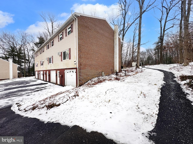 view of snow covered exterior with a garage