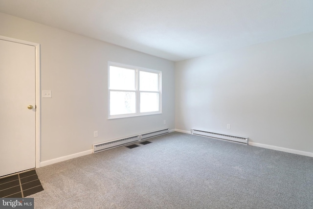 carpeted empty room featuring a baseboard heating unit