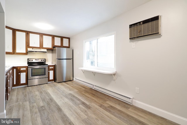 kitchen with light hardwood / wood-style flooring, baseboard heating, appliances with stainless steel finishes, tasteful backsplash, and a wall unit AC