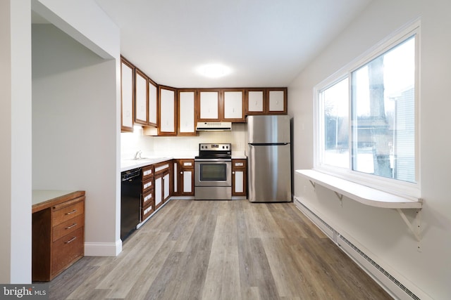 kitchen with sink, stainless steel appliances, light wood-type flooring, and a baseboard heating unit