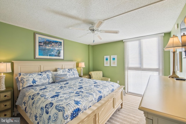 bedroom with ceiling fan, light carpet, and a textured ceiling