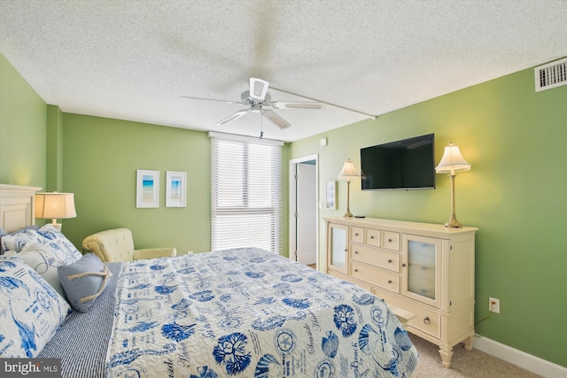 carpeted bedroom with ceiling fan and a textured ceiling