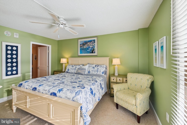 bedroom featuring ceiling fan, carpet floors, and a textured ceiling