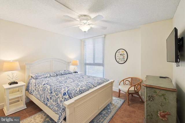 tiled bedroom with ceiling fan and a textured ceiling