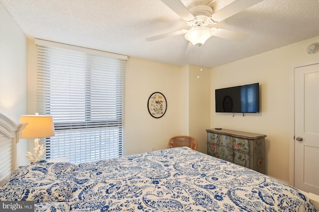 bedroom with a textured ceiling and ceiling fan