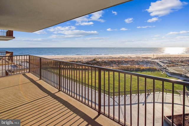 balcony featuring a water view and a beach view