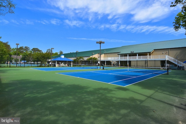 view of tennis court featuring a gazebo and basketball hoop