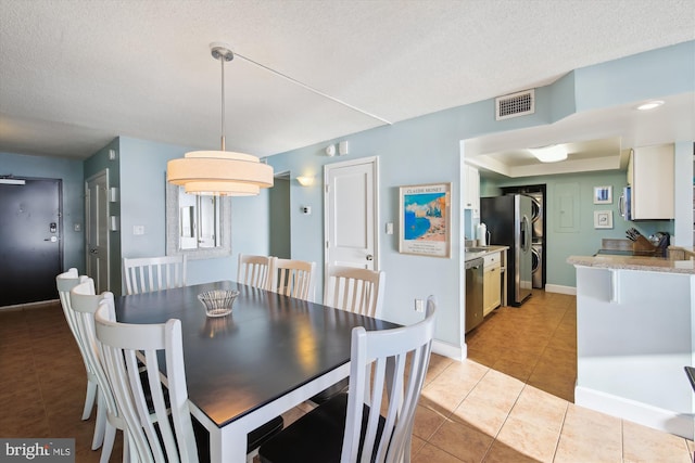 tiled dining room featuring a textured ceiling