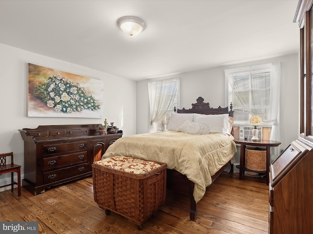 bedroom with hardwood / wood-style flooring, cooling unit, and multiple windows