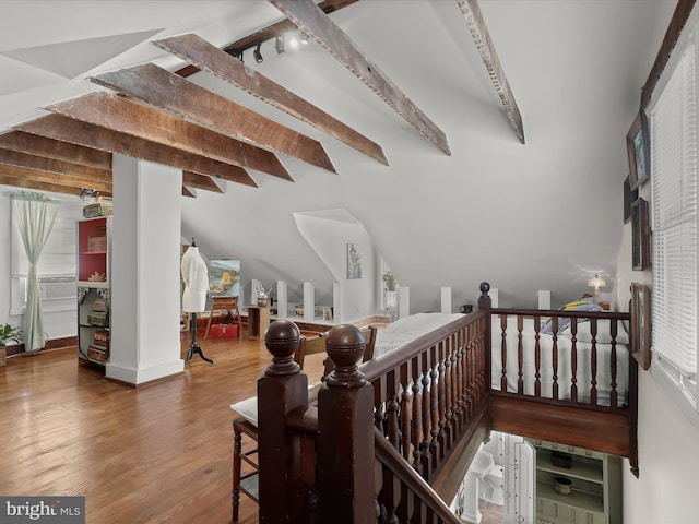 interior space with hardwood / wood-style floors, vaulted ceiling with beams, and a nursery area