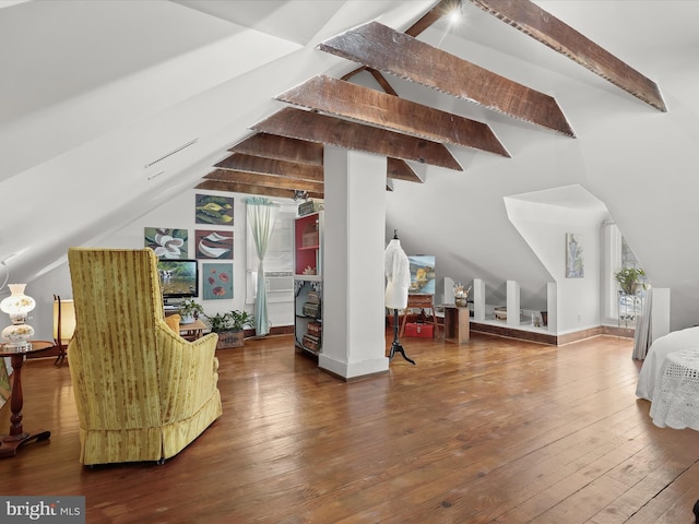 additional living space featuring wood-type flooring and vaulted ceiling with beams