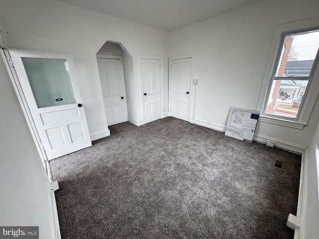 unfurnished bedroom with dark colored carpet