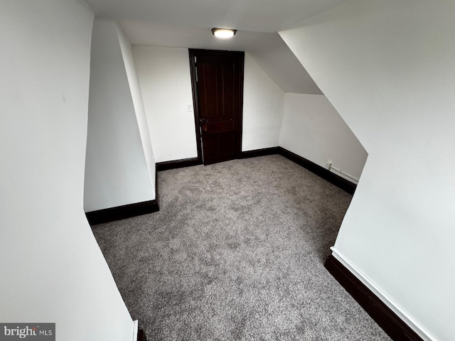 bonus room with carpet flooring and vaulted ceiling