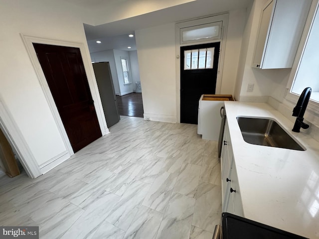 kitchen featuring white cabinetry and sink