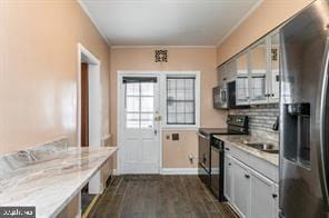 kitchen with electric range, dark hardwood / wood-style floors, stainless steel fridge, and crown molding