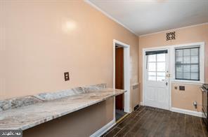 entryway featuring ornamental molding and dark wood-type flooring