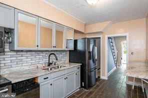 kitchen with light stone counters, dark wood-type flooring, electric stove, sink, and stainless steel fridge with ice dispenser