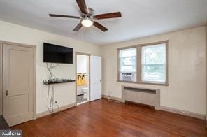 unfurnished living room with radiator, ceiling fan, and dark wood-type flooring