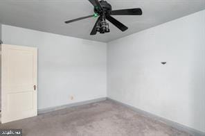 carpeted spare room featuring ceiling fan