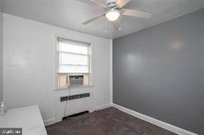 interior space with dark colored carpet, ceiling fan, and radiator heating unit