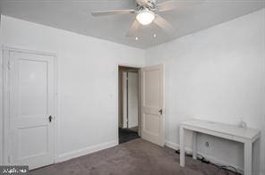 unfurnished bedroom featuring dark colored carpet and ceiling fan