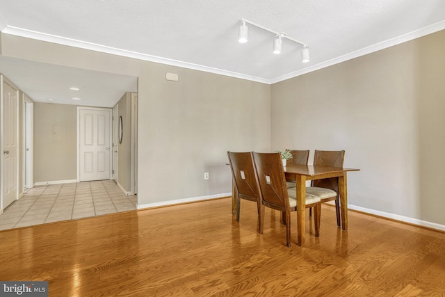 dining room featuring light wood-type flooring and ornamental molding