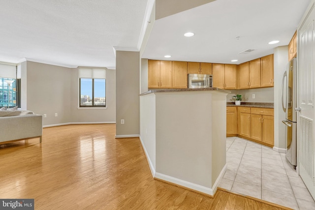 kitchen with crown molding, light hardwood / wood-style flooring, and appliances with stainless steel finishes