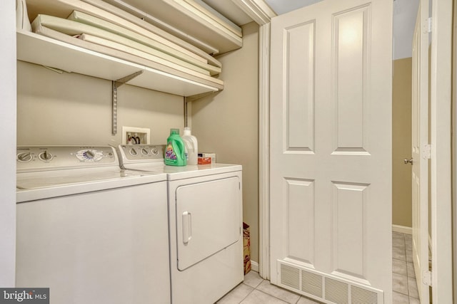 laundry room featuring washer and clothes dryer and light tile patterned floors