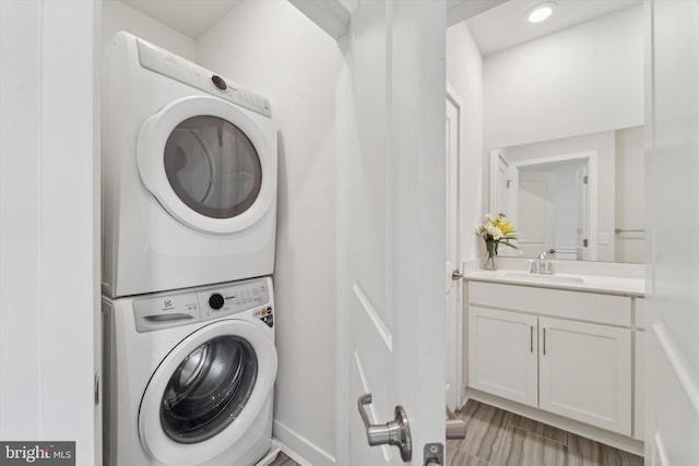 washroom featuring stacked washer and dryer and sink