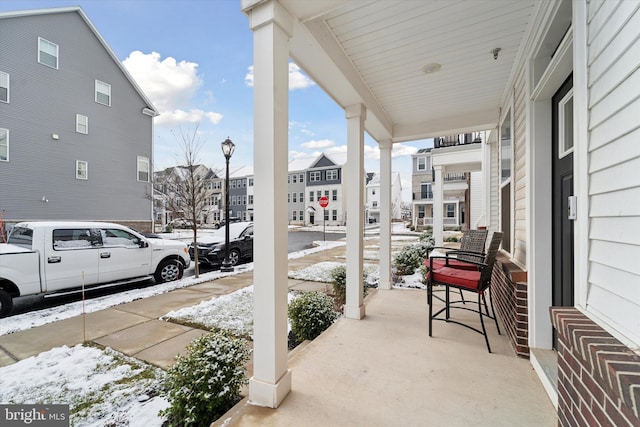 snow covered patio with a porch