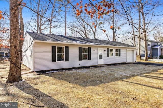 ranch-style house with a garage and a front lawn