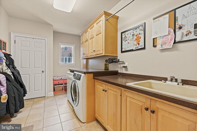 washroom with cabinets, light tile patterned flooring, washer and clothes dryer, and sink